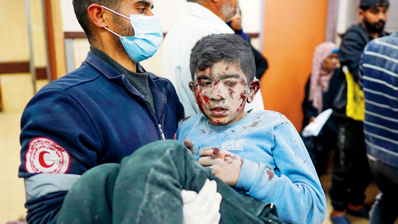 A medic carries a wounded Palestinian boy. PIC/AP