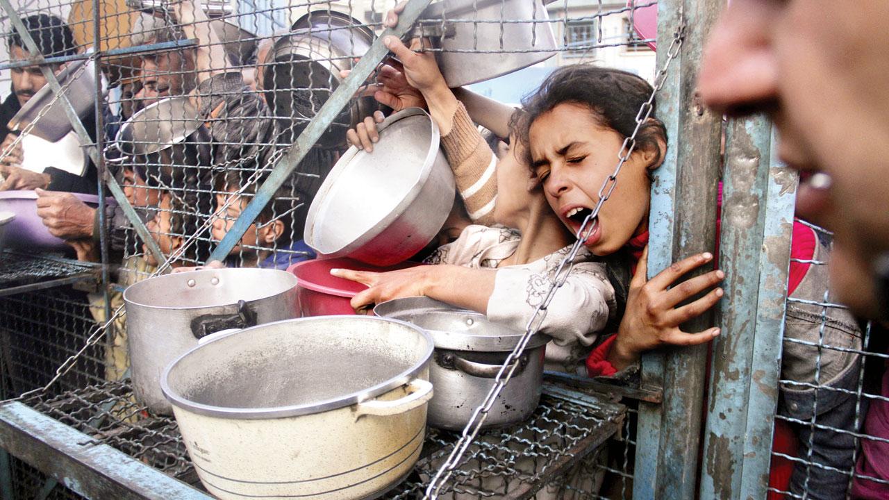 Palestinians line up to receive free meals at Jabaliya refugee camp in the Gaza Strip. Pic/AP