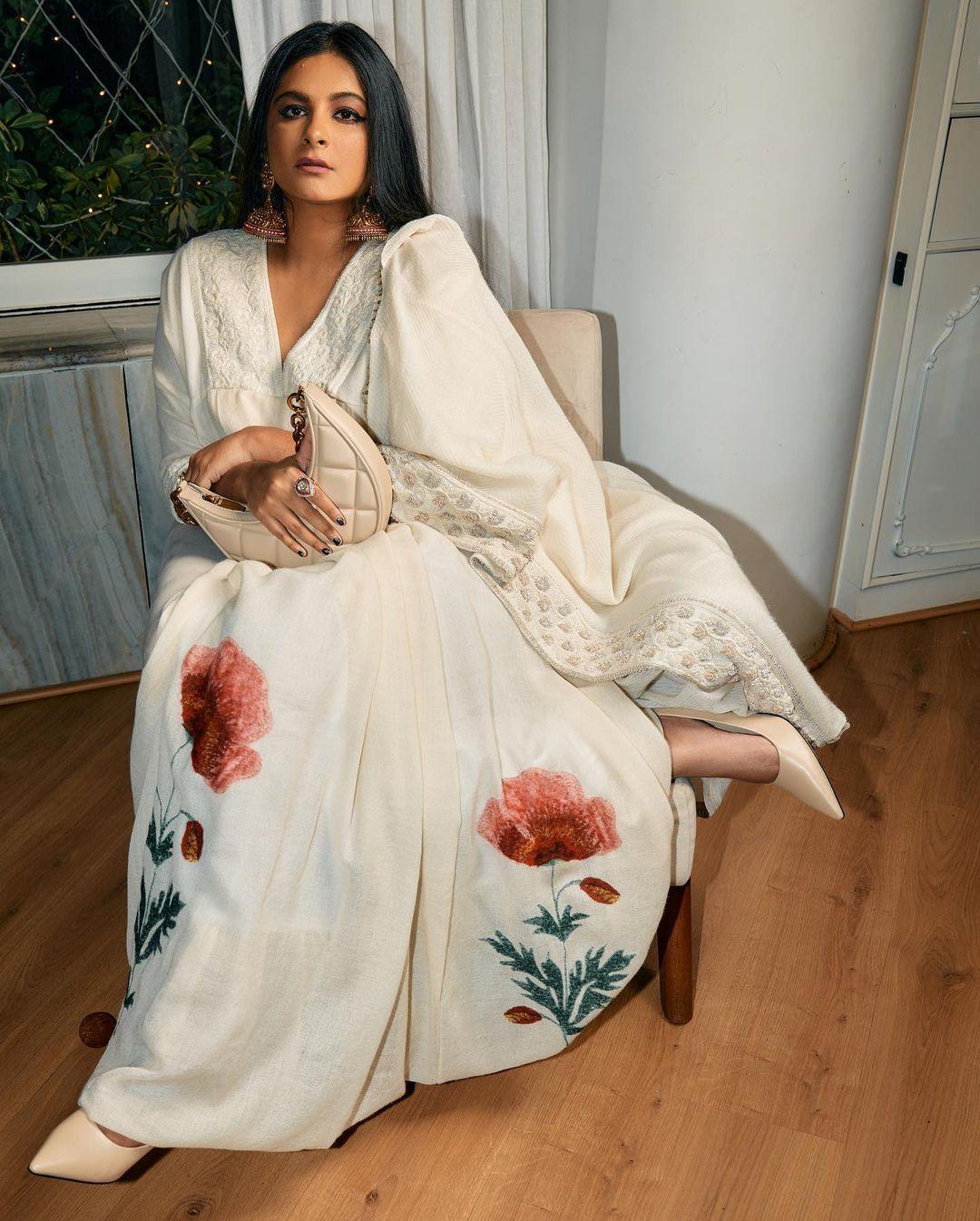 This stunning white kurta with a minimal flower design can be your best choice for a simple look. The actress further elevated her appearance by wearing giant red jhumkas. She left her hair open and applied simple makeup to maintain the white and red balance. Rhea wore cream sandals to finish her look