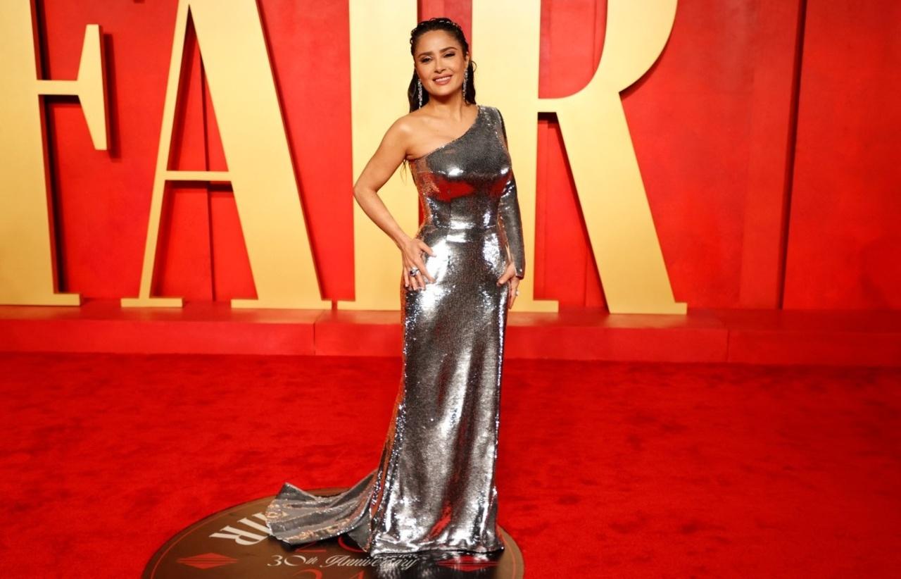 Salma Hayek defied age as she wore a metallic silver one-shoulder gown. 