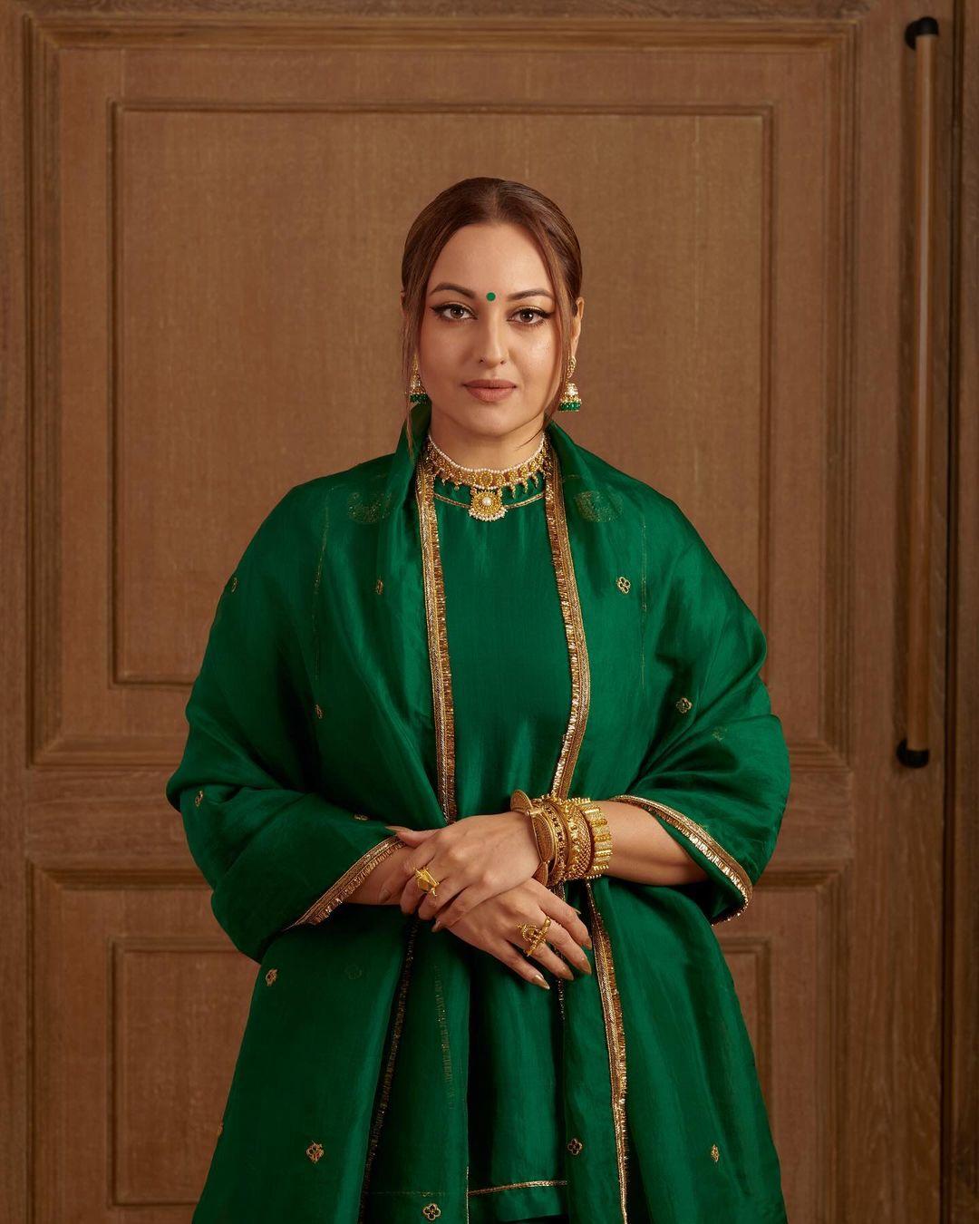 Sonakshi Sinha looked stunning in an all-green ensemble. The actress donned a short kurta paired with a matching skirt and complemented it with a dupatta featuring a contrasting golden border. She elegantly tied her hair in a chic bun, with two hair flicks framing her face and enhancing her overall look