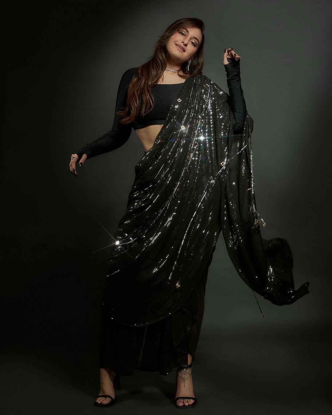 One can never go wrong with black, and Sonakshi has proved it right with this appearance. The actress paired a shiny black saree with a matching full-sleeved blouse