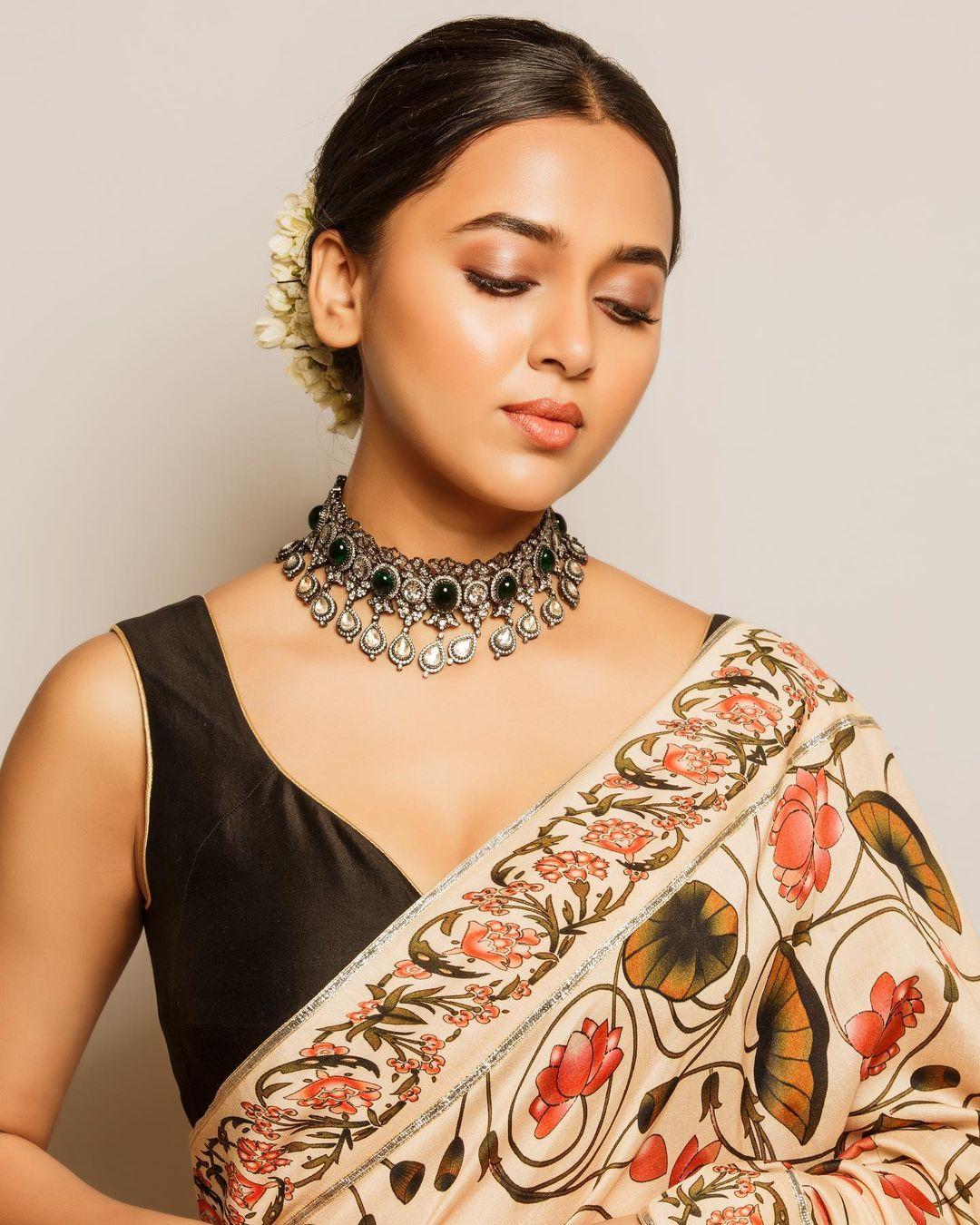 To elevate your look further, style your hair in a chic bun and put minimal nude makeup. Just for some extra masala, add an intricate necklace like Tejasswi, and you are ready to ace
