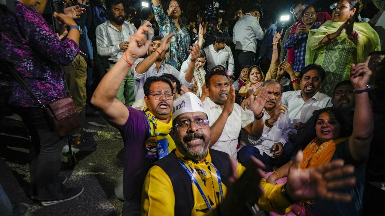 AAP supporters shout slogans in favour of Arvind Kejriwal outside his residence. Pics/PTI and Satej Shinde