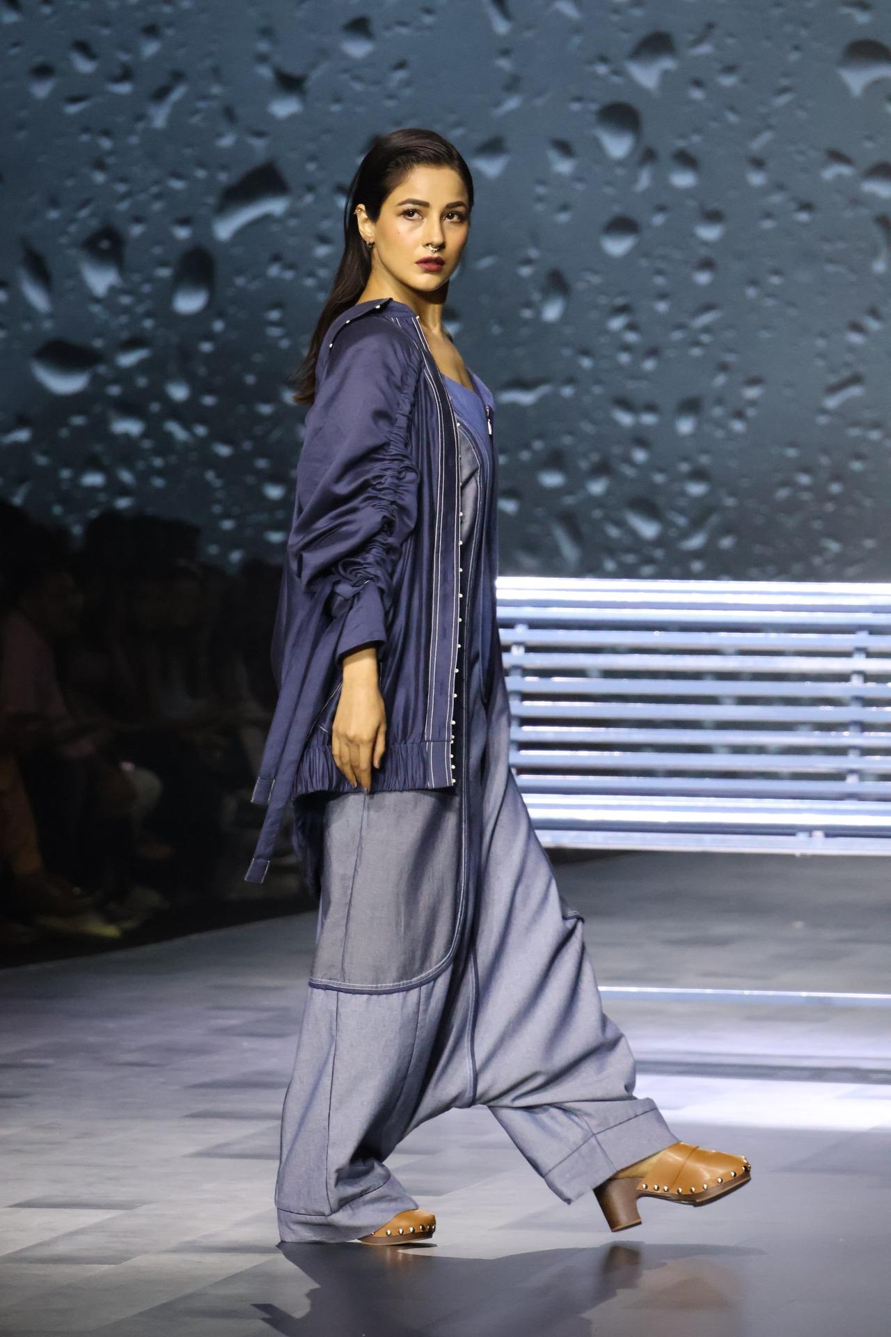 Shehnaaz was seen splashing on the runway in a baggy jumpsuit with strap sleeves and a jacket layered to add that oomph element