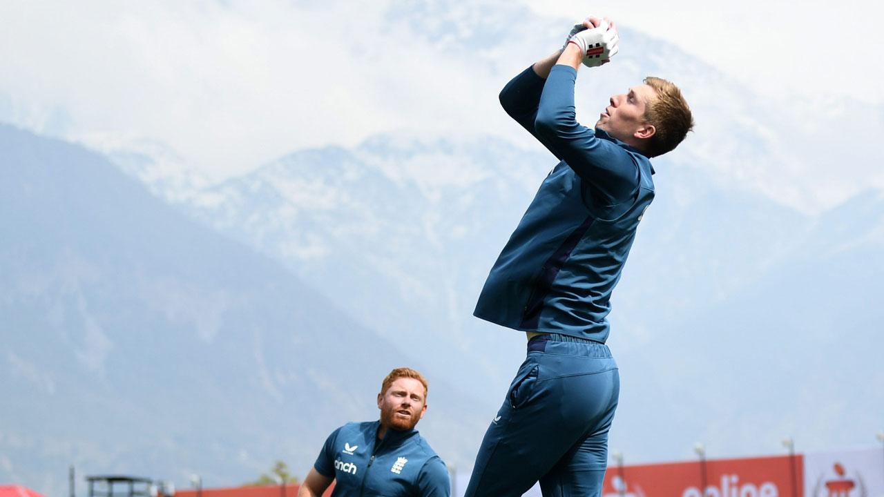 England’s Zak Crawley (right) catches in the slips as Jonathan Bairstow and Ben Duckett (left) look on yesterday