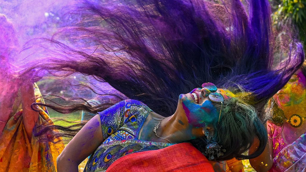A young woman drenched in colours celebrates Holi, in Nadia. Image courtesy: PTI