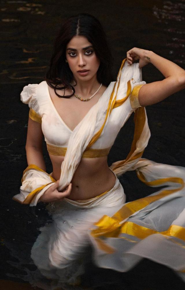 Janhvi Kapoor mesmerises in this water baby look as she flaunts a white saree with golden border and the signature puffed blouse from the vintage era. 