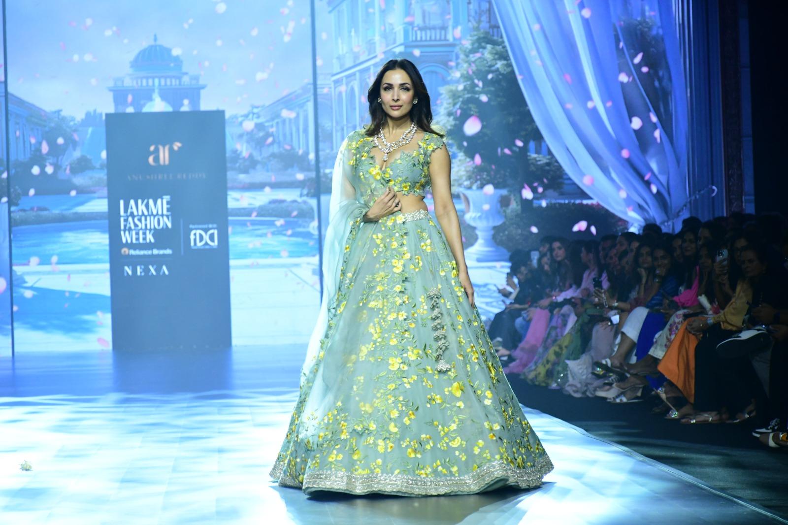 Malaika Arora graced the runway for Anushree Reddy and Ritika Mirchandani during Day 4 of Lakme Fashion Week in collaboration with FDCI. She donned a stunning blue lehenga embellished with intricate yellow floral patterns on the skirt