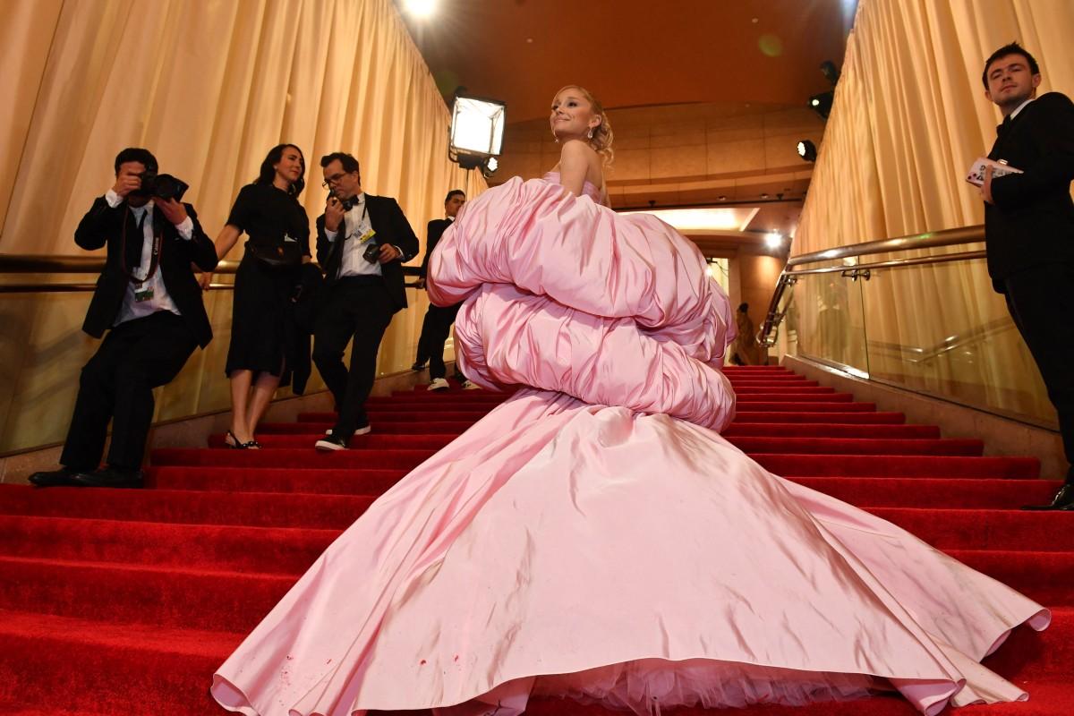 Ariana Grande made a striking appearance on the red carpet, donning a voluminous pink bubble dress designed by Giambattista Valli, a nod to her character Glinda
