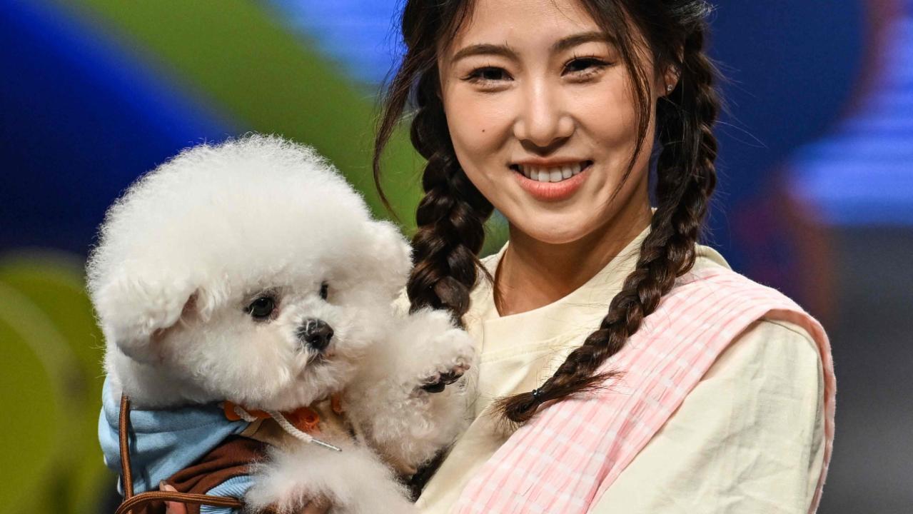 Chinese pet lover poses with her dog at the fashion show. Pic/AFP