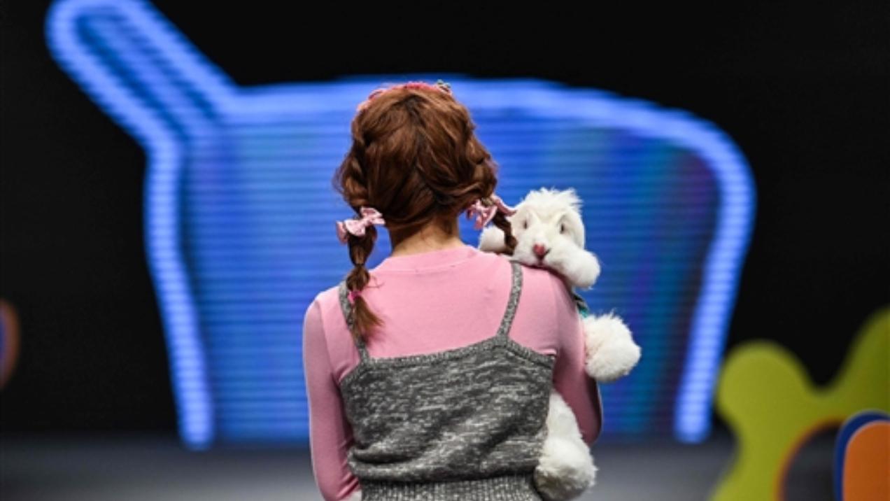 A model parades down the runway at the pet fashion show, as she delicately cradles a fluffy rabbit in her arms