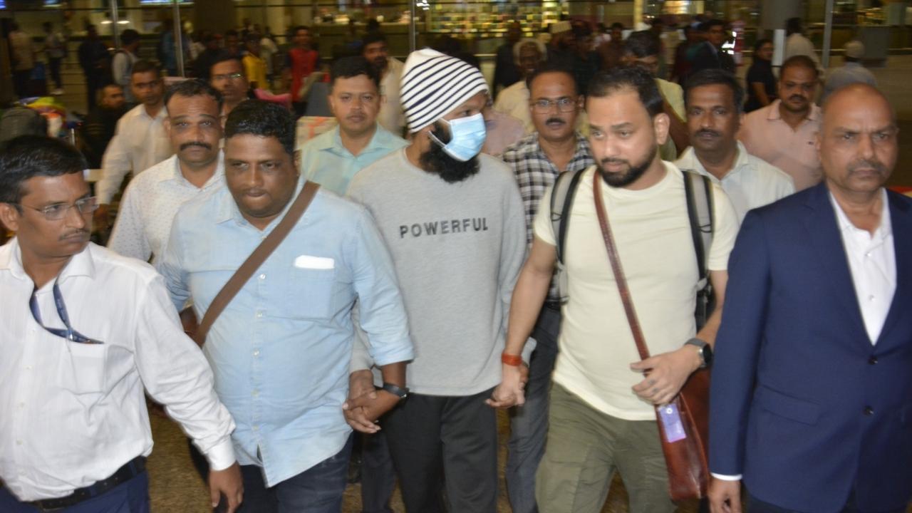 Prasad Pujari in cap and mask, at Mumbai airport on Friday night. Pics/Mumbai Police sources