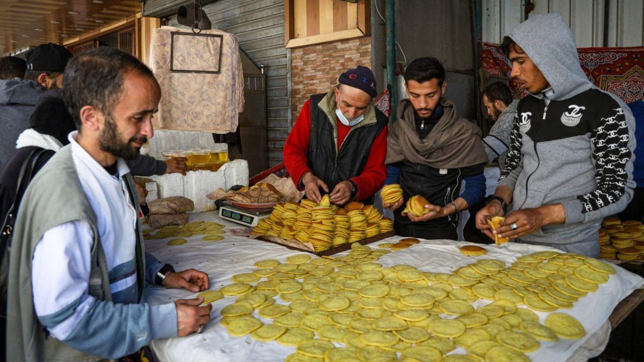 Palestinians make Qatayef, traditional pancakes made during the Muslim holy fasting month of Ramadan in Rafah in the southern Gaza Strip on March 12, 2024, amid ongoing battles between Israel and the militant group Hamas. (Photo by AFP)