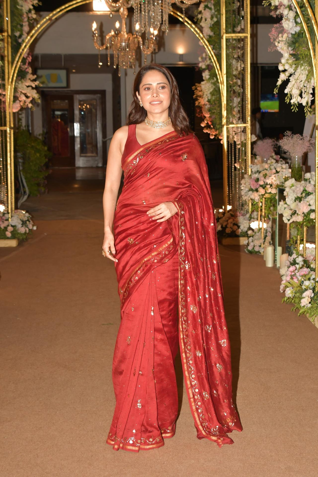 Nushrratt Bharuccha wore a red saree with golden embroidery. The actress paired it with a stylish intricate necklace and small stud earrings to finish her look