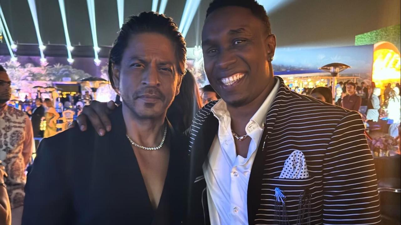 Bollywood superstar Shah Rukh Khan posed with West Indies cricketer Dwayne Bravo. He wore a black blazer with trousers sans a shirt. 