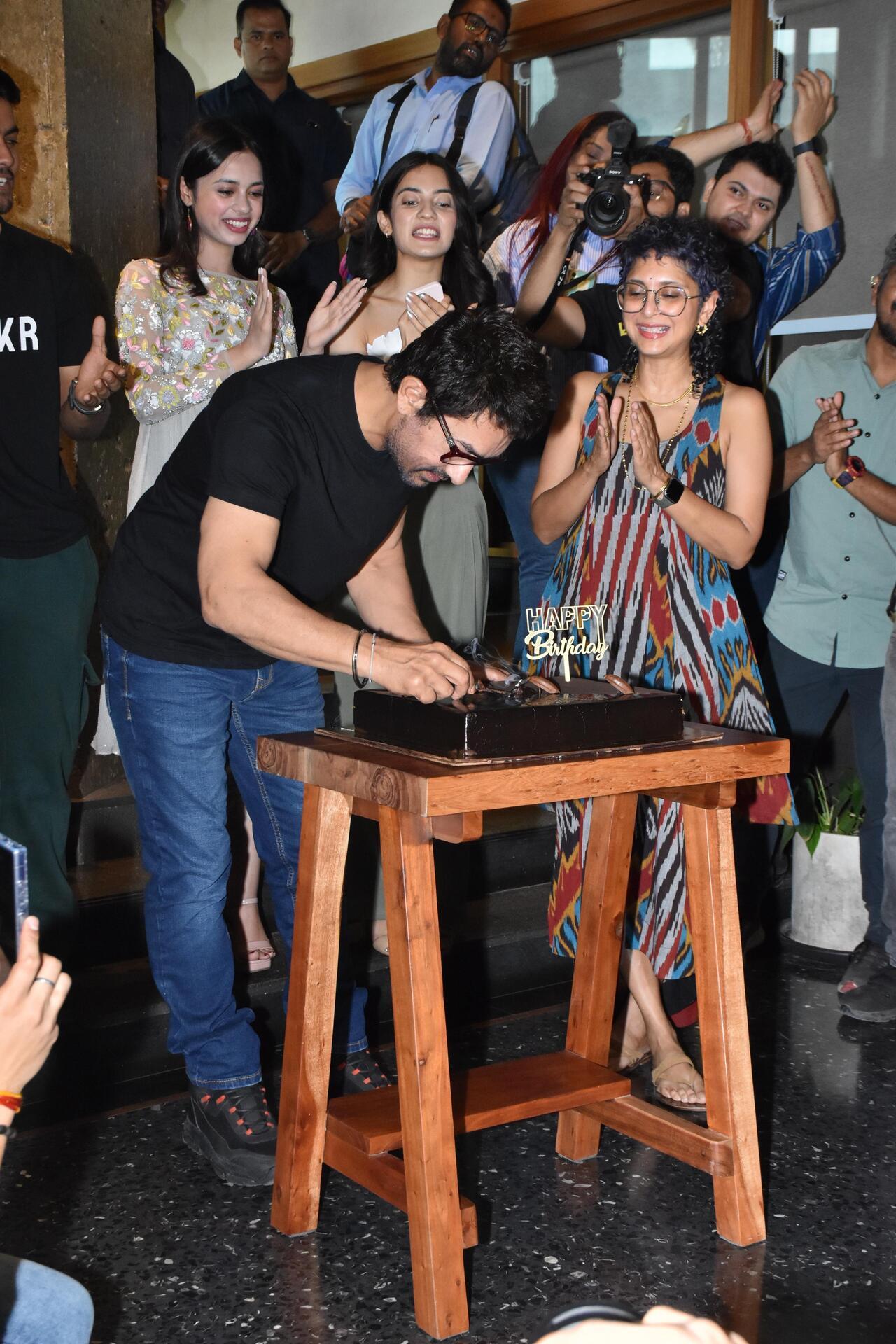 Aamir Khan cuts his cake as he celebrates his 59th birthday with the media