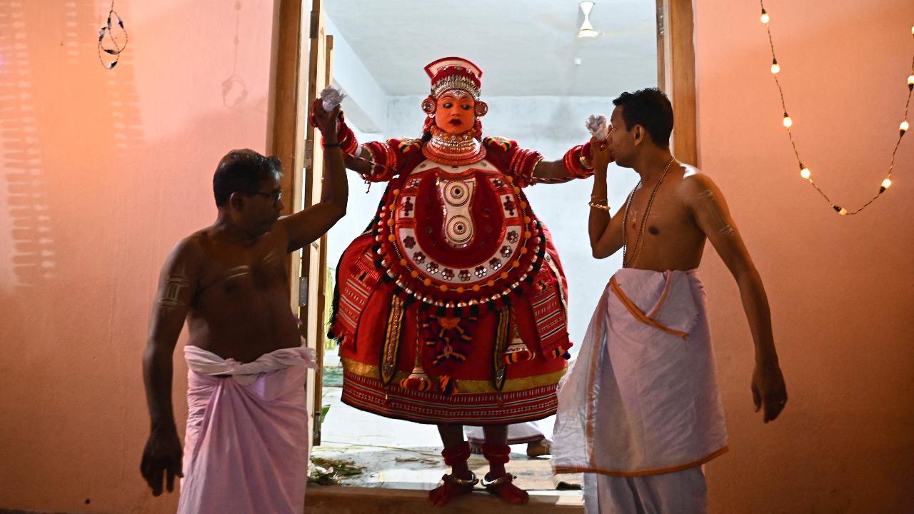 A man, dressed as the Hindu deity Sasthappan, arrives to perform during the traditional dance festival 'Theyyam' also known as 'Kaliyattam', at Muthappa Swami temple in Somwarpet