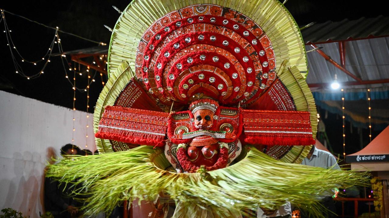 An Indian artist dressed as the Hindu deity Bhagawathy performs during the traditional dance festival Theyyam. Image courtesy: AFP