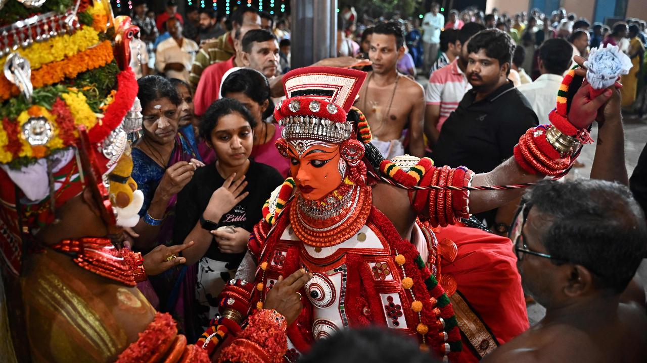  A man is dressed as the Hindu deity Sasthappan during the ritualistic dance ceremony of Theyyam