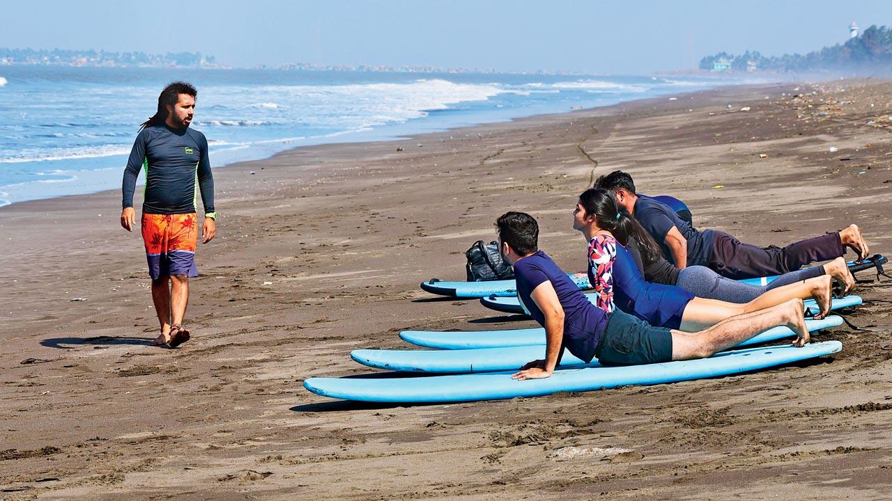 First timers are taught how to balance themselves on a surfboard at Rajodi