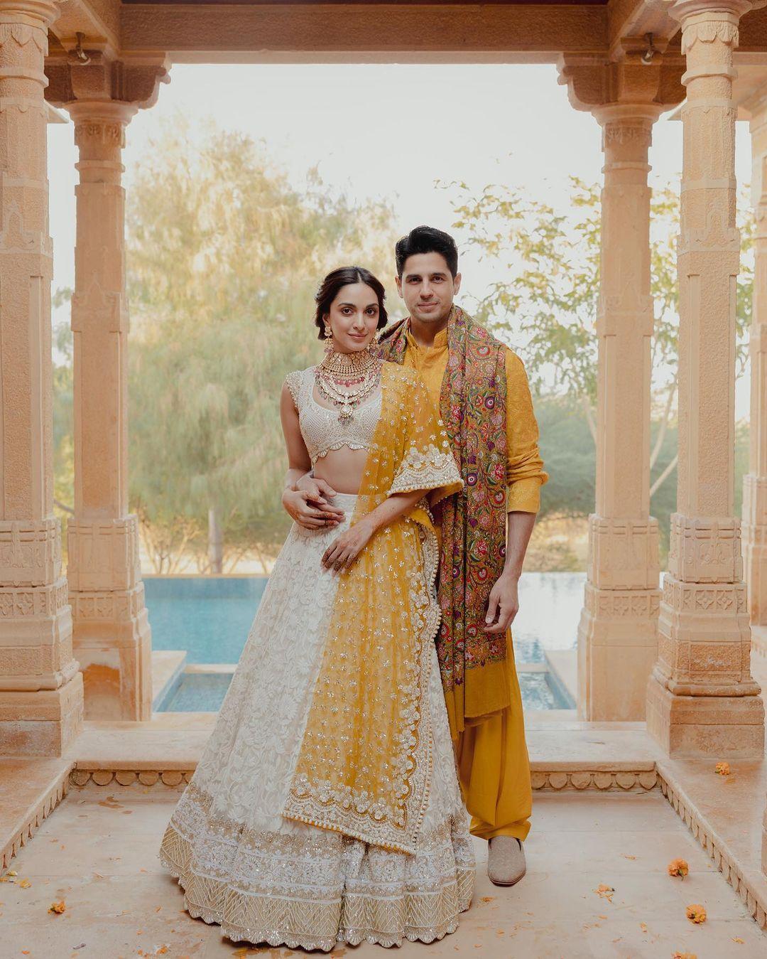Kiara Advani wore a light-colored beige cream for her Mehendi ceremony. The actress paired her lehenga with a bright yellow dupatta and wore a stylish heavy necklace which had pink gems to it. While Sidharth Malhotra complemented his lady love in a yellow Pathani paired with a printed shawl