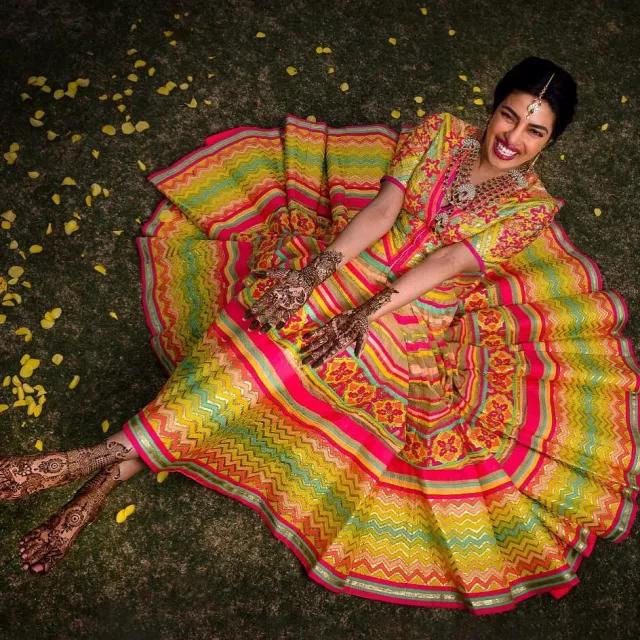 Oh, goodness! How pretty does Priyanka Chopra look in her Mehendi ceremony outfit? The actress opted for a beautiful multicoloured lehenga. She tied her hair in a chic bun. While forgoing heavy jewelry, she paired an intricate necklace with simple earrings and a sleek maangtika