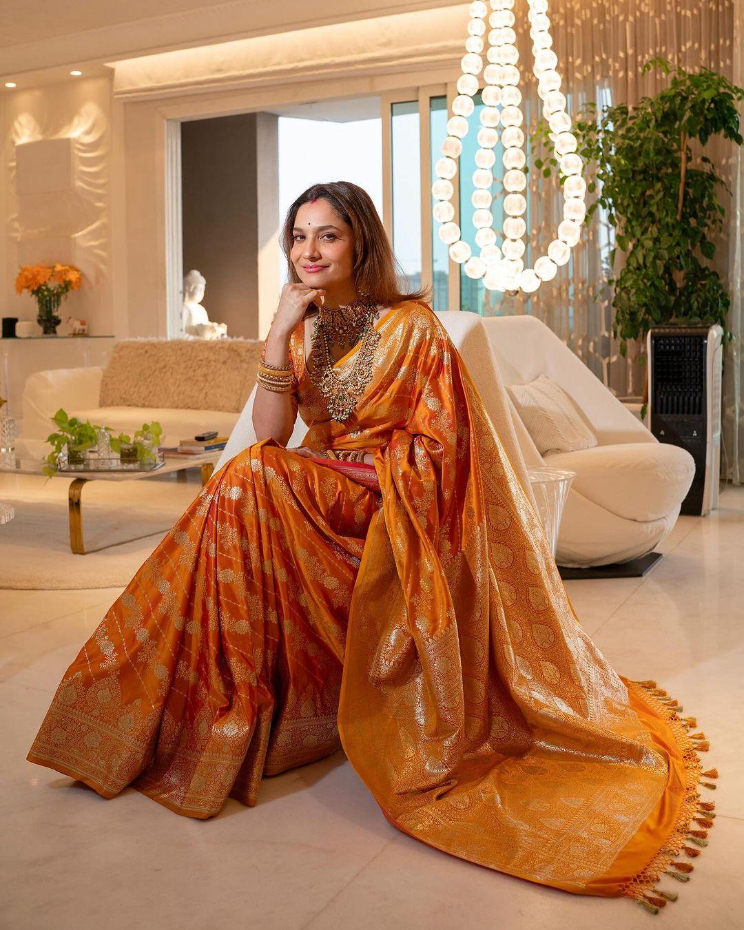 In this breathtaking picture, Ankita wore a beautiful orange saree with golden embroidery all over it. The actress styled her saree with a matching blouse