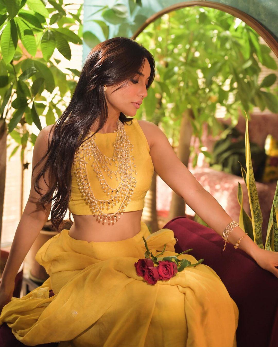 The actress wore a stunning yellow crop top and paired it with a matching long skirt. By adding a pearl necklace, she gave it an indo-western touch