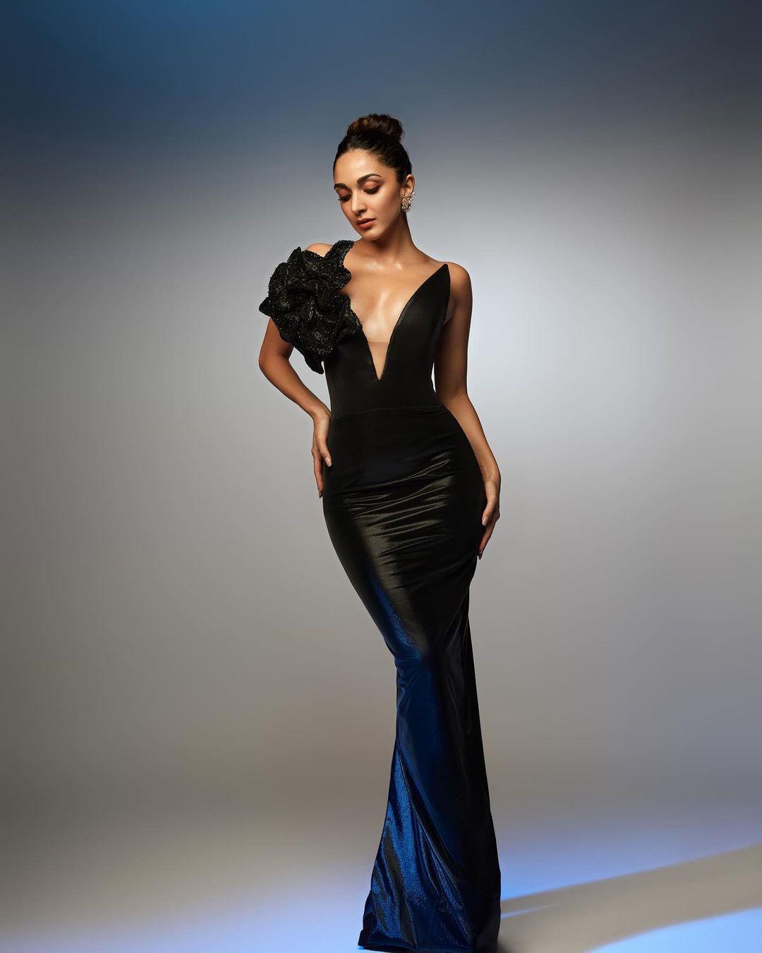 Kiara Advani wowed in a sleek black bodycon gown featuring a deep neckline and a large 3D flower on the shoulder