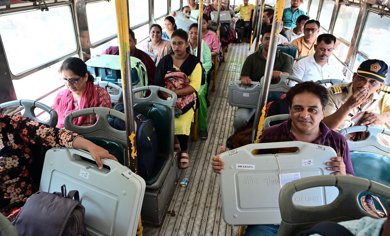 Polling officers carry Electronic Voting Machines (EVMs) from a distribution centre at D'Silva High School in Dadar ahead of the upcoming Lok Sabha elections in 2024