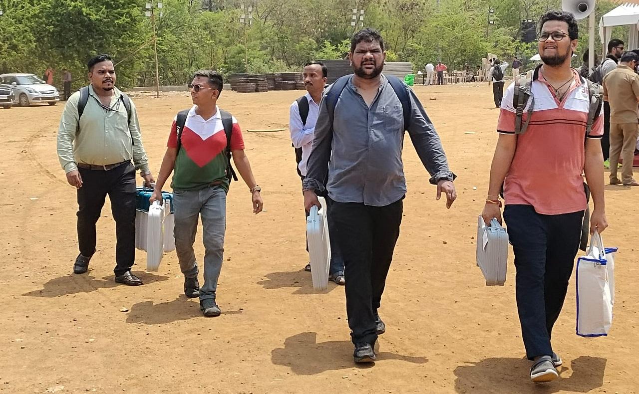 Polling officers carry Electronic Voting Machines (EVMs) from a distribution centre at Ismail Yusuf College Ground in Jogeshwari ahead of the upcoming Lok Sabha elections in 2024