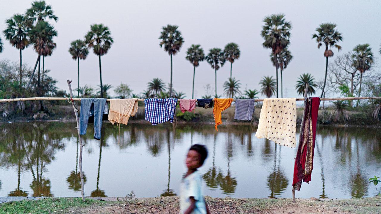 A child plays near a clothesline amidst the forest fires in Mayurbhanj