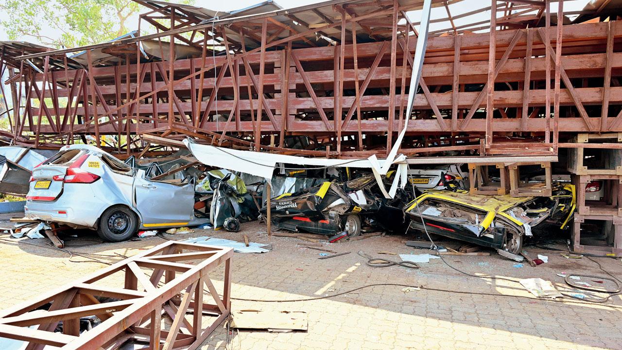 Automobiles squashed flat beneath the massive hoarding. Pic/Shadab Khan