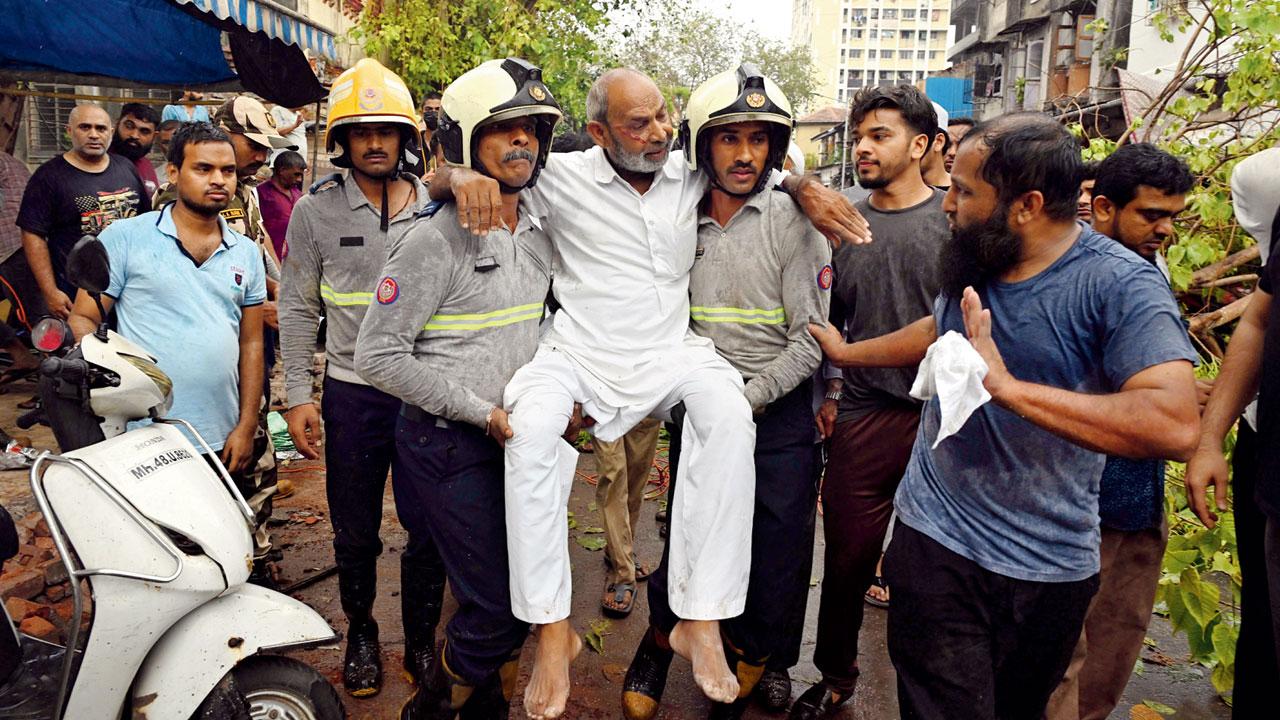A hawker, who was injured in a tree fall at Kapad Bazar, Mahim, rescued by the fire brigade. Pic/Ashish Raje
