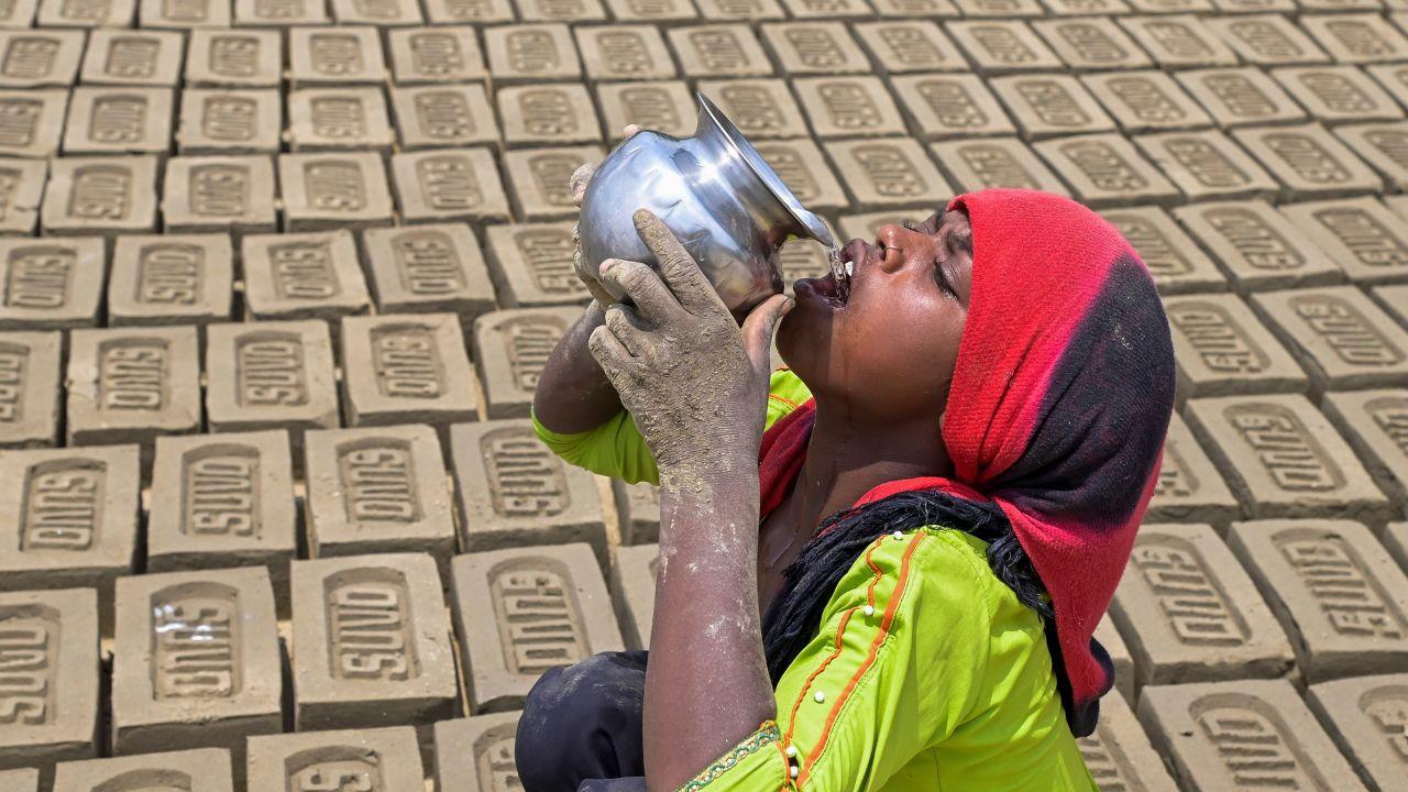 A labourer drinks water to quench her thirst during a hot summer day, in Nadia, Friday, May 24, 2024. (PTI Photo)