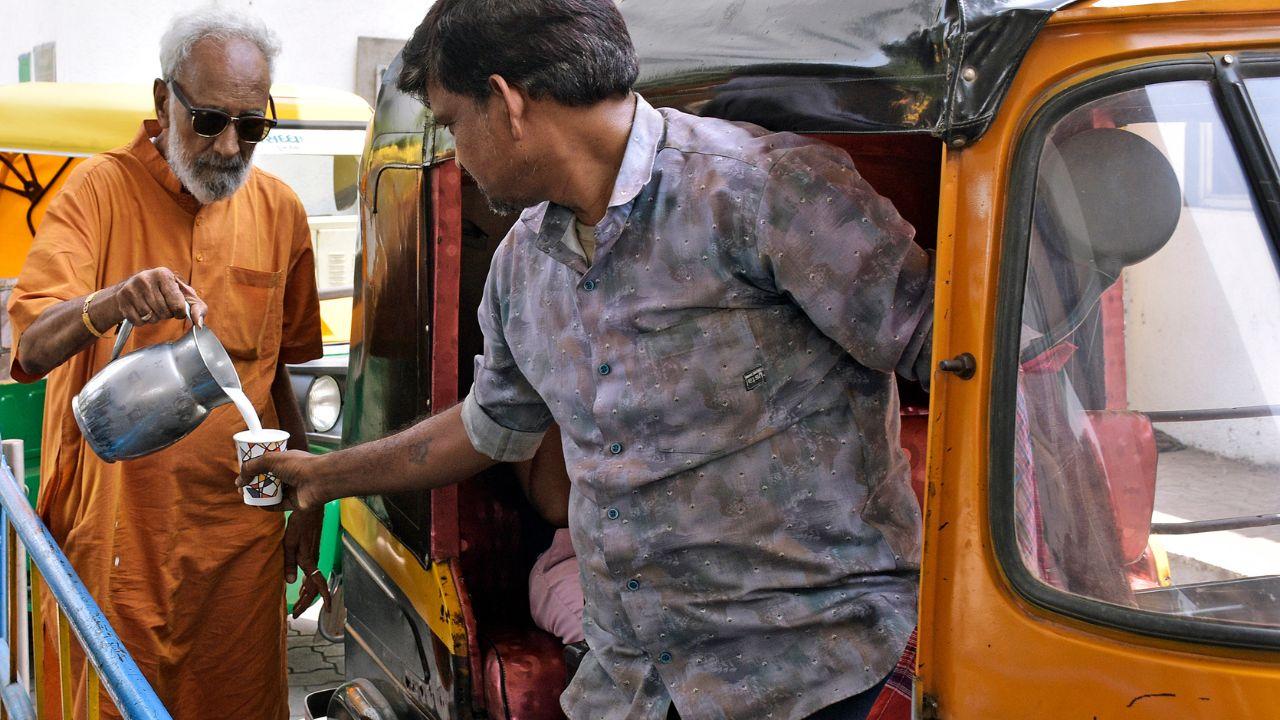 A member of the Jain community distributes 'Chaas' to an autorickshaw driver to beat the heat on a hot summer day, in Surat on Thursday.