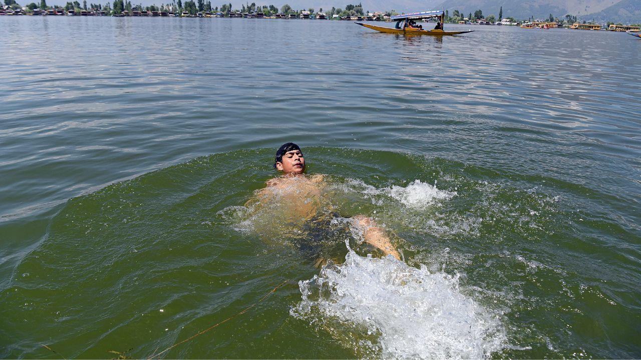A boy swims in the dal lake to beat the heat on a hot summer day, in Srinagar on Thursday. (ANI Photo/Imran Nissar)