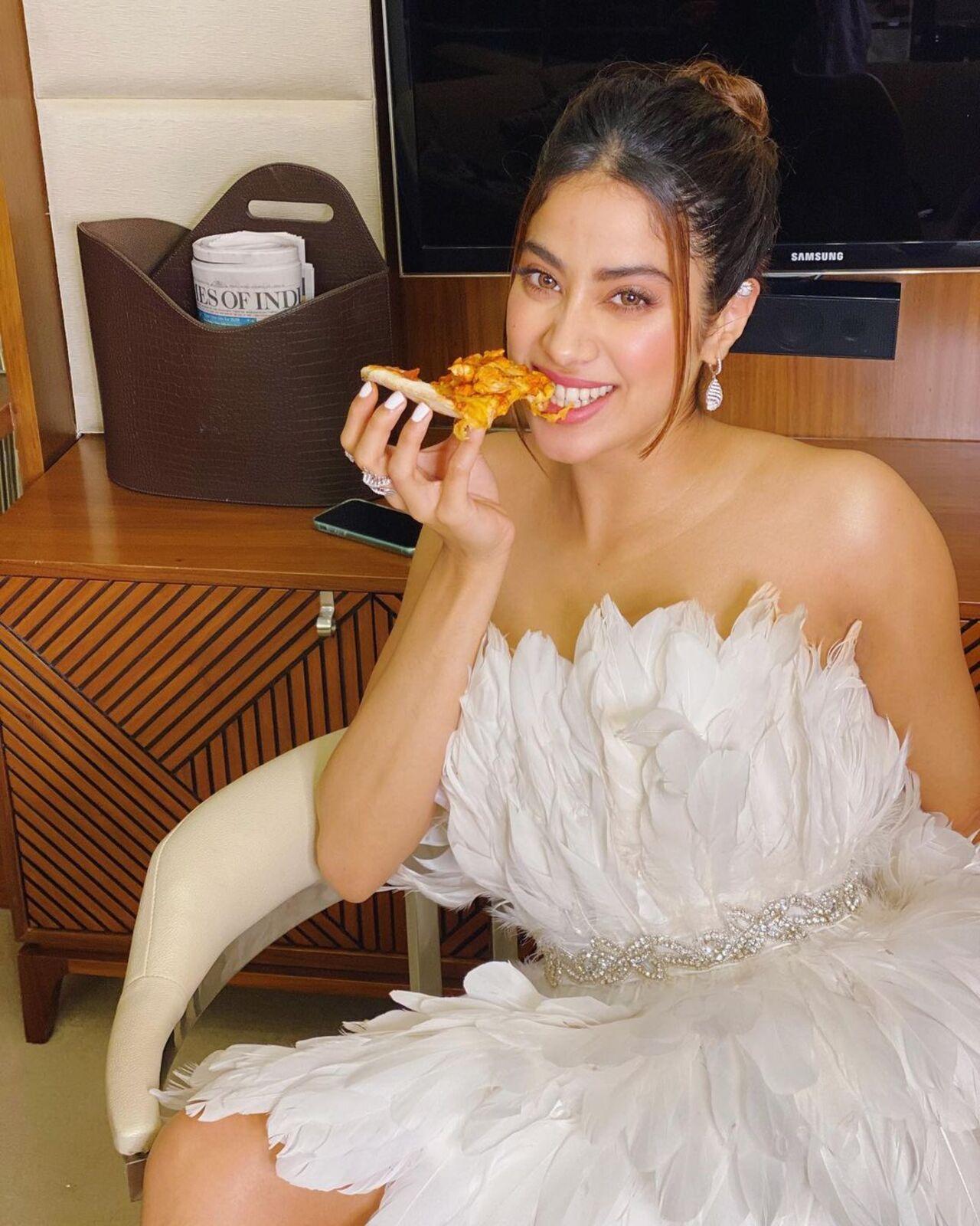 Here’s Janhvi downing a slice of pizza while getting ready for a fashionable appearance. 