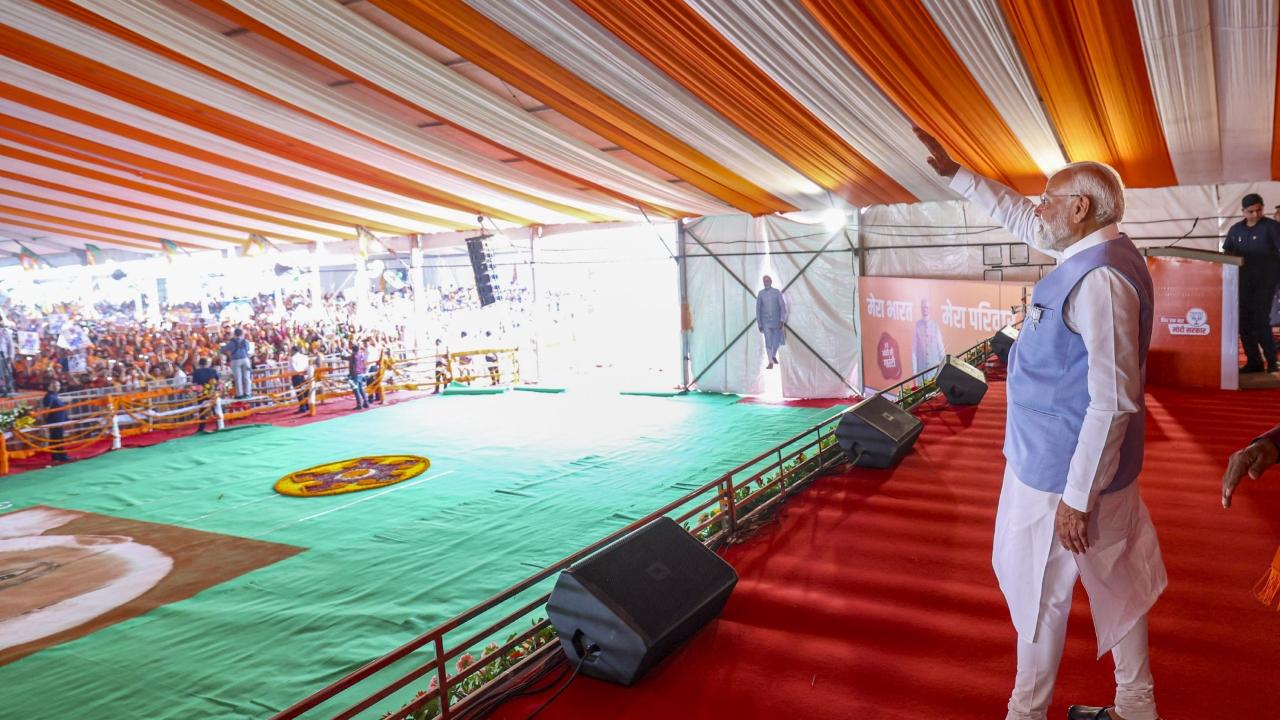 Prime Minister Narendra Modi holds a trident during a public meeting for Lok Sabha elections 2024