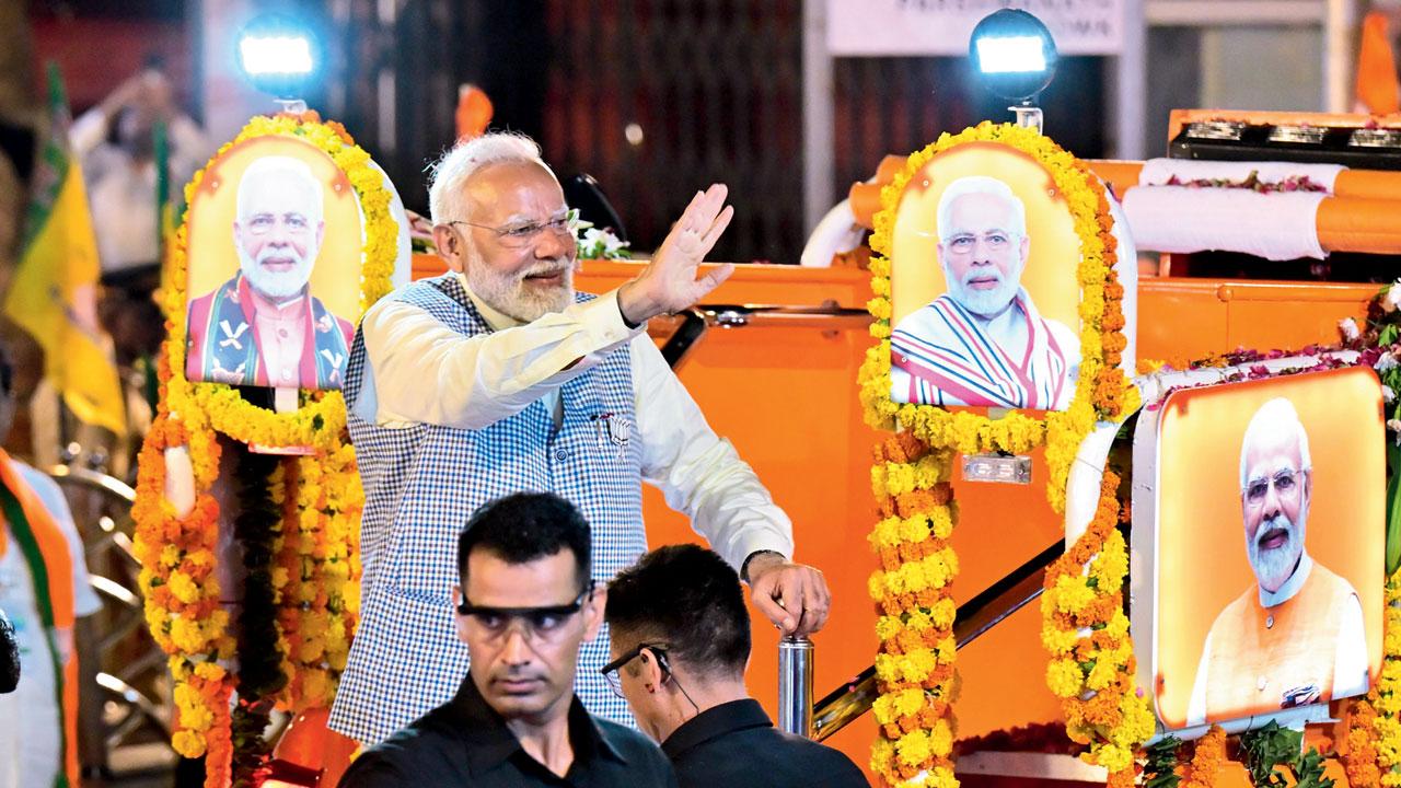 PM Modi at waving at the crows during the road show. Pic/Shadab Khan