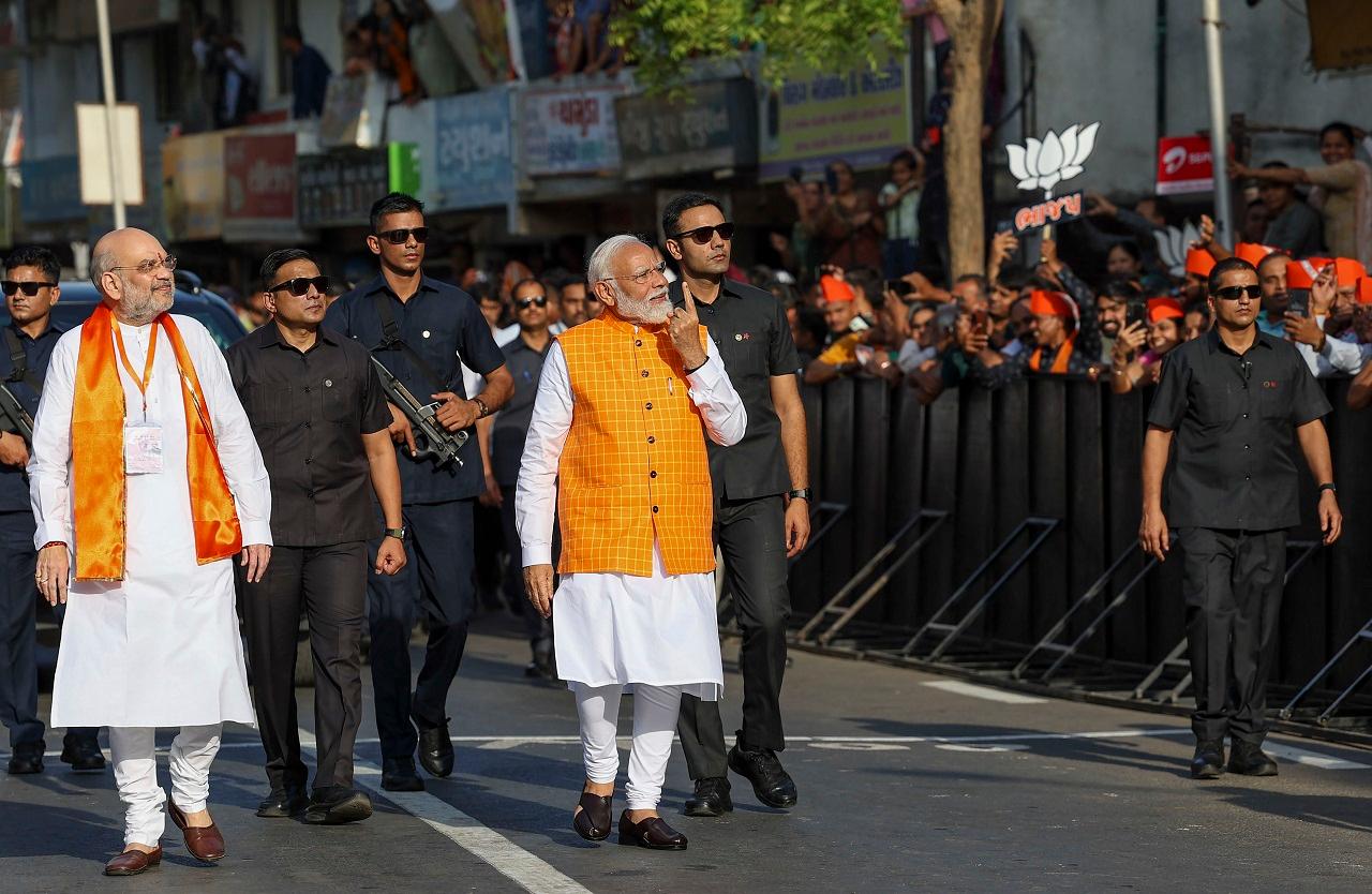 PM Modi greeted people, signed autographs on his way to the polling booth. He bowed down to his elder brother Somabhai Modi before entering the polling booth