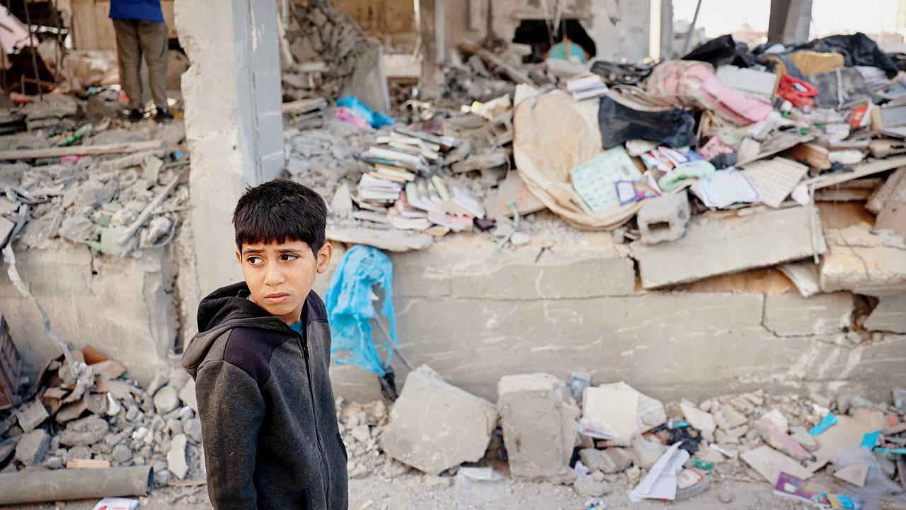 A Palestinian child stands in front of a building destroyed by Israeli bombing in Rafah. PIC/ AFP