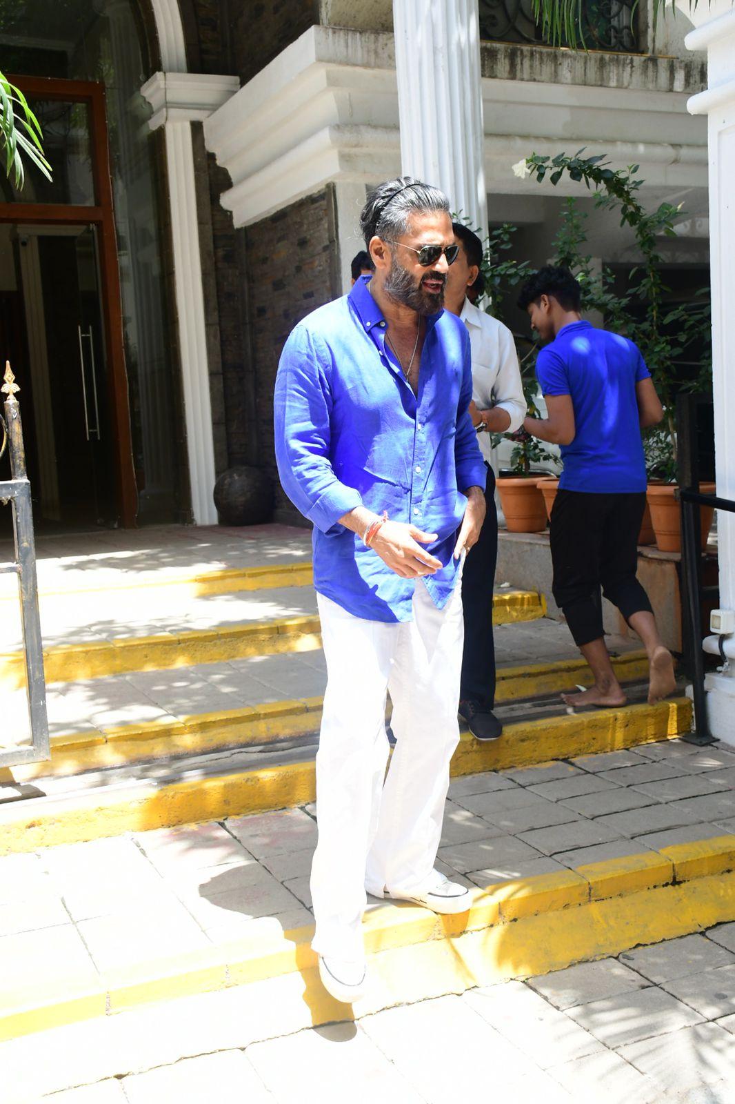 Suniel Shetty opted for a blue shirt and paired it with white pants as he go out