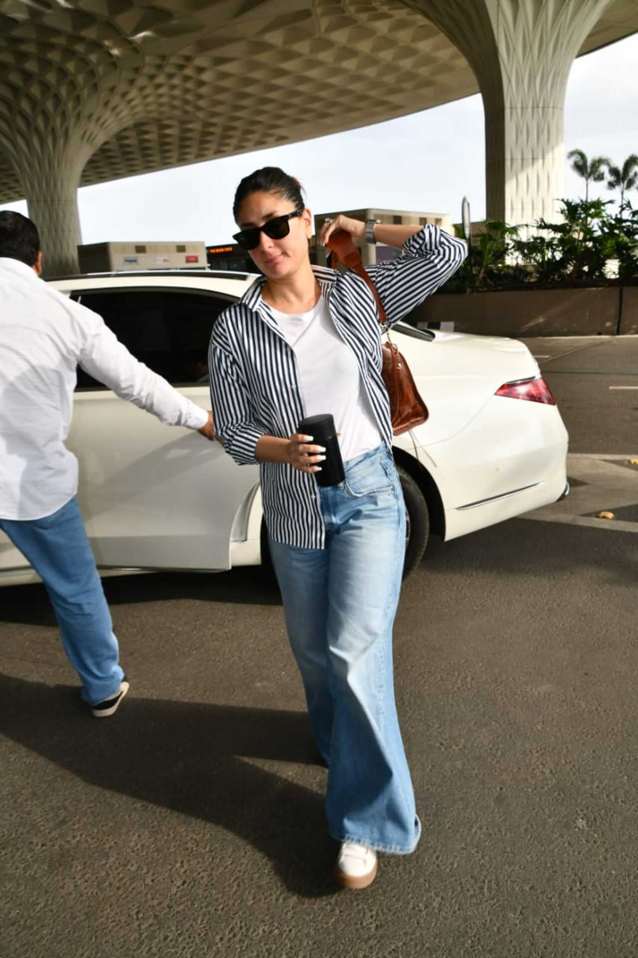 Scores of celebs jetted off to Italy for the pre-wedding festivities of Anant Ambani and Radhika Merchant. Fashion icon Kareena Kapoor Khan sashayed in style wearing a white tank top with a striped shirt and jeans. 