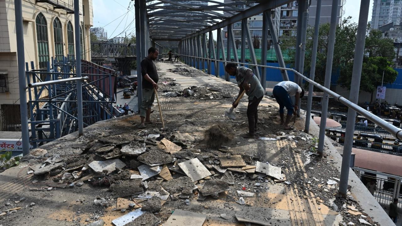 The civic workers on Sunday dismantling the floor of the Skywalk in Bandra. Pics/Ashish Raje 