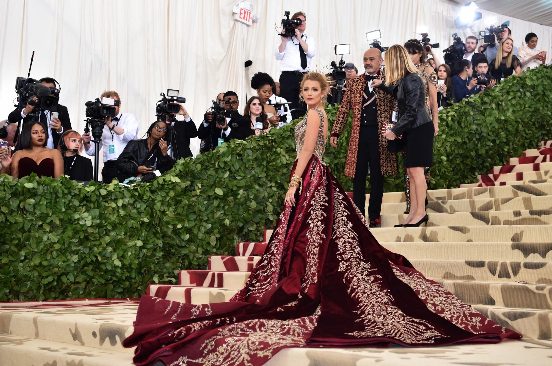 Blake Lively rocked a stunning crimson Versace gown at the 2018 MET Gala, featuring a beautifully embroidered bodice, jewelled straps, and an incredibly long train, all painstakingly crafted by hand over 600 hours. (Pic/AFP)