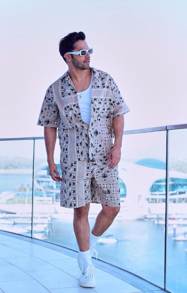 Bringing his signature energy to his wardrobe, Varun Dhawan opts for light-colored playful printed shirts and shorts.