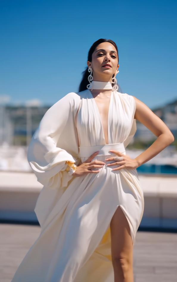 The actor wore an ivory outfit with a deep neckline and a thigh-high slit, paired with large matching earrings and heels.