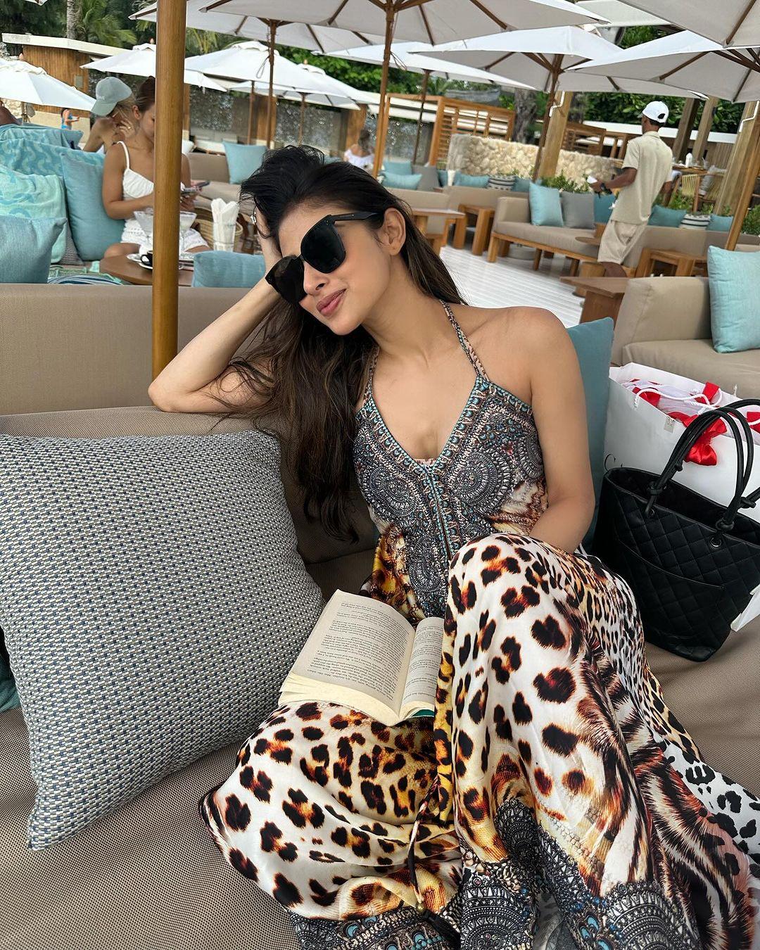 While on vacation, Mouni Roy wore a flowing dress with a unique leopard print at the bottom, which became the standout feature of the outfit.
